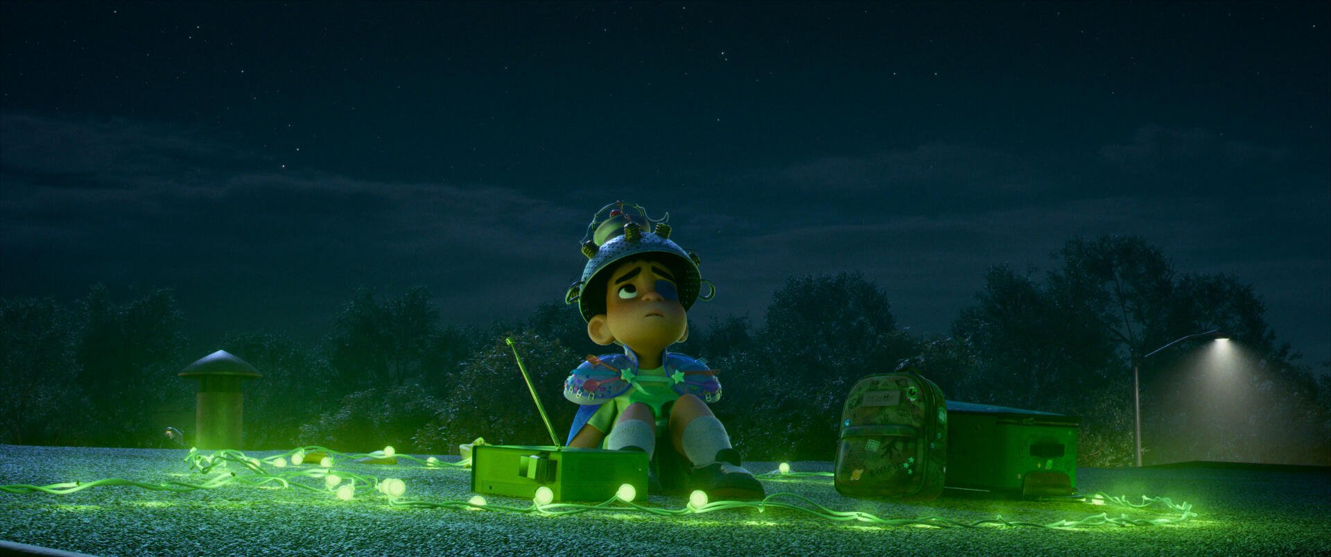 A scene from the movie Elio (2025), featuring a young character sitting amidst glowing green lights at night, creating a whimsical, adventurous atmosphere. 4K Ultra HD wallpaper.