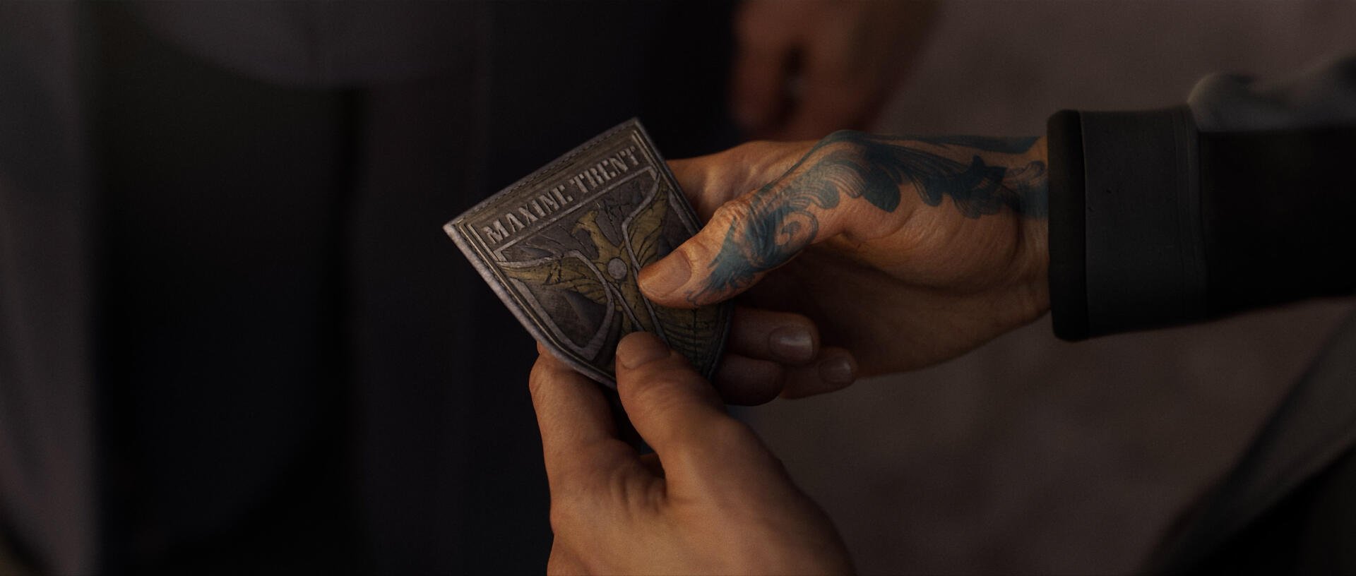 A close-up of a hand holding a detailed metal insignia, set against a blurred background, from the video game Exodus (2024), making a striking HD desktop wallpaper.