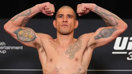 Alex Pereira flexes confidently at a UFC weigh-in, showcasing his tattoos and muscular physique, captured in vibrant 4K Ultra HD as a striking desktop wallpaper.