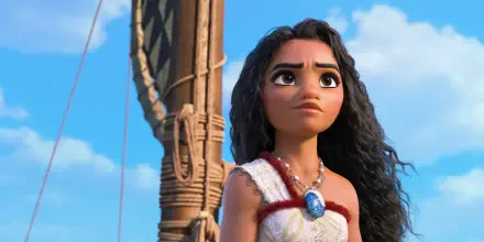 Moana Waialiki from Moana 2 gazes determinedly into the distance, set against a vibrant blue sky, capturing her adventurous spirit in this HD desktop wallpaper.