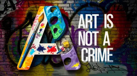 A vibrant 4K Ultra HD wallpaper featuring the phrase Art Is Not A Crime alongside a colorful letter A adorned with paint and brushes, set against a graffiti background.