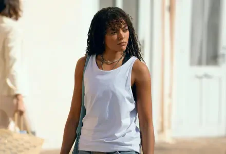 Quintessa Swindell from the TV show Prime Target stands outdoors, wearing a white tank top, captured in an 8K Ultra HD PC desktop wallpaper and background.