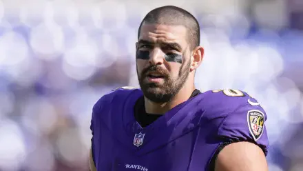 Close-up of Mark Andrews, NFL player for the Baltimore Ravens, wearing a purple jersey and eye black, captured during a game, showcasing determination and athleticism.
