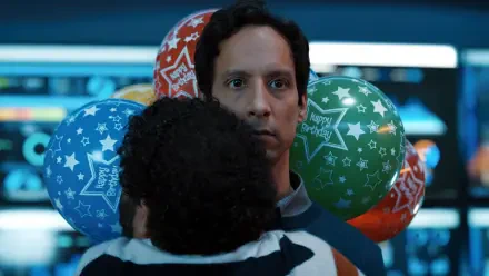 A scene from the TV show Mythic Quest featuring Jessie Ennis. The image shows a character with balloons in the background, capturing a moment of surprise or celebration.