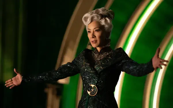A still from the movie Wicked, featuring Michelle Yeoh in a stunning green and black costume, set against a vibrant background. This image serves as a striking 4K Ultra HD desktop wallpaper.