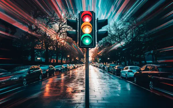 A striking 4K Ultra HD image of a traffic light, featuring vibrant green, yellow, and red lights, set against a reflective street with blurred motion effects.