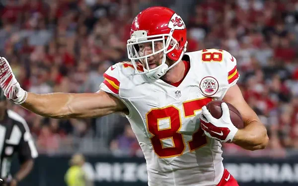 Travis Kelce of the Kansas City Chiefs celebrates a play on the field, showcasing his athleticism in this vibrant NFL-themed HD desktop wallpaper.