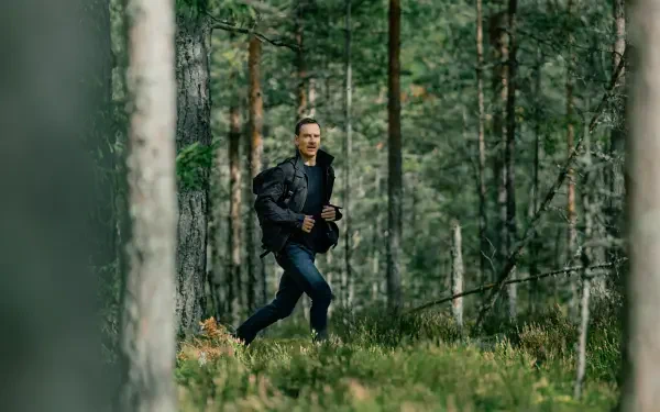 A scene from the TV show The Agency, featuring Michael Fassbender running through a lush green forest, captured in stunning 4K Ultra HD.