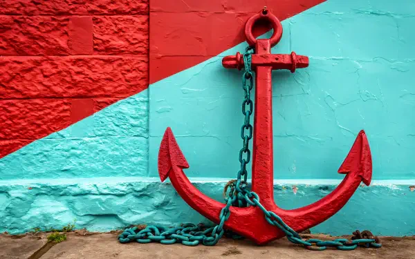 A vibrant red anchor with a chain stands against a colorful turquoise and red wall, creating a striking visual suitable for a 4K Ultra HD desktop wallpaper and background.