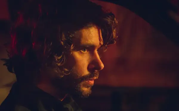 A close-up of Ben Whishaw in a dramatic scene from the TV show Black Doves, featuring rich colors and a moody atmosphere, presented as a 4K Ultra HD desktop wallpaper.