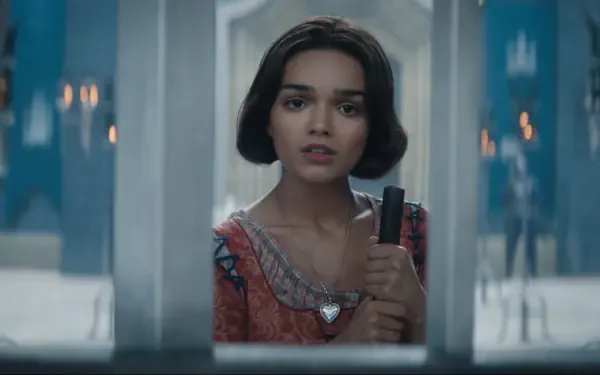 Rachel Zegler portrays Snow White in this HD desktop wallpaper from the 2025 film, capturing an expressive moment as she holds a dagger, framed by a mysterious setting.