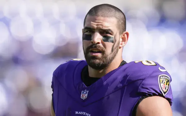Close-up of Mark Andrews, NFL player for the Baltimore Ravens, wearing a purple jersey and eye black, captured during a game, showcasing determination and athleticism.