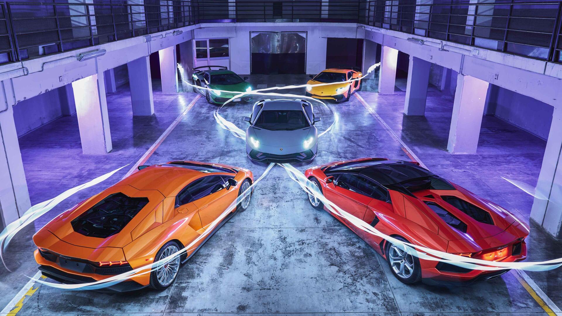 Three Lamborghini supercars in a neon-lit parking garage—orange, red and silver with dynamic light trails; 4K Ultra HD PC desktop wallpaper background.