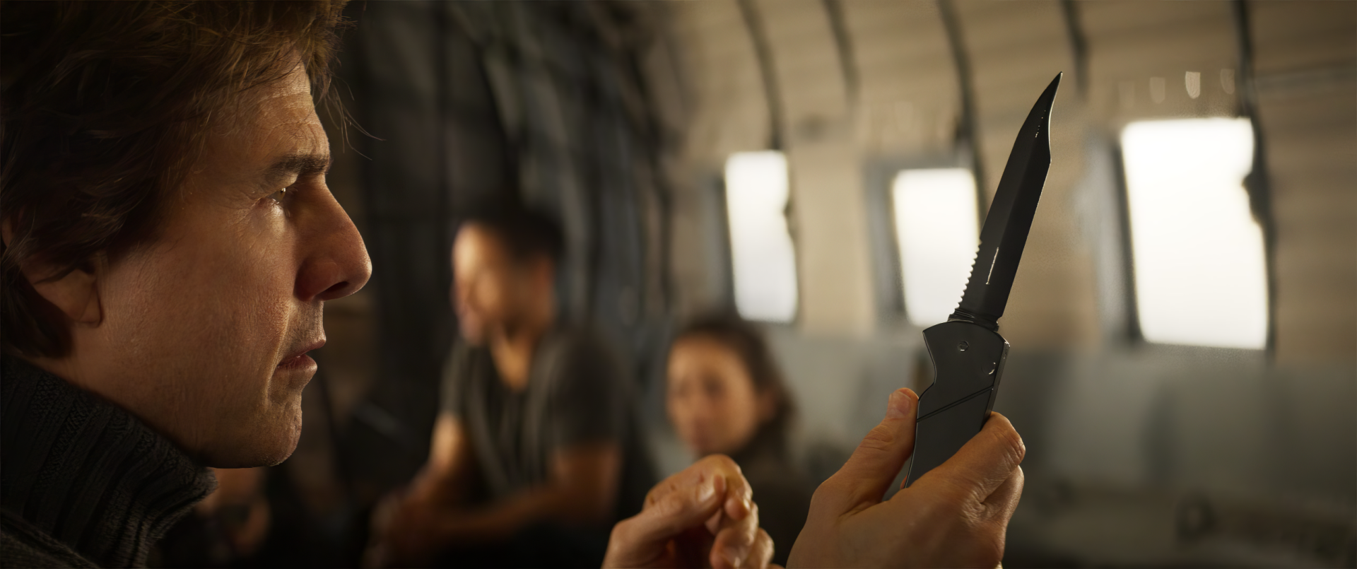 Tom Cruise focuses intently on a knife in a scene from Mission: Impossible - The Final Reckoning. The image serves as a striking HD desktop wallpaper.