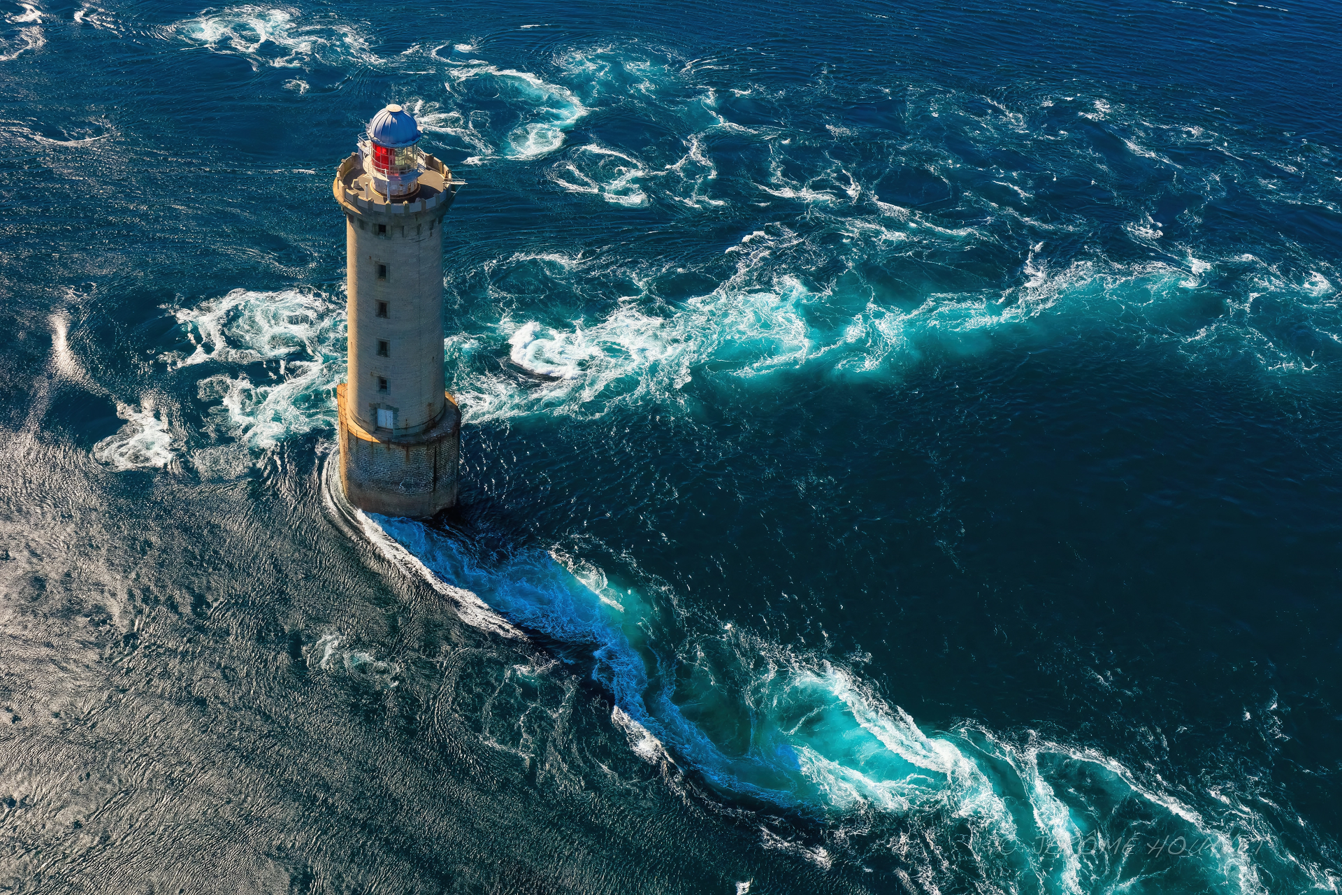 A 4K Ultra HD PC wallpaper featuring a solitary lighthouse standing firm amidst powerful ocean waves crashing around it.