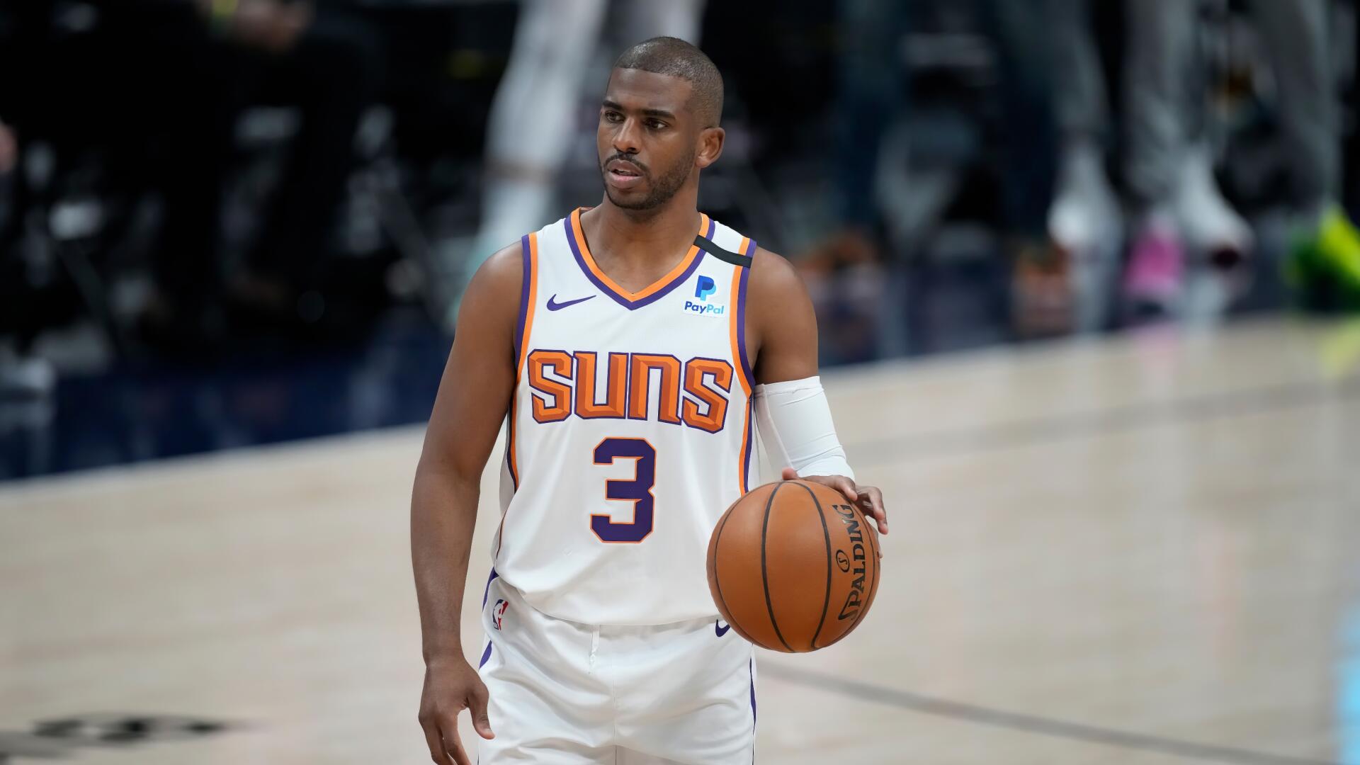 HD basketball wallpaper featuring NBA player Chris Paul in his Phoenix Suns uniform, dribbling on the court during a game.