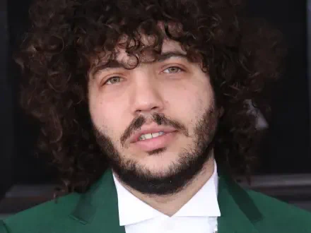 Close-up of Benny Blanco, featuring his curly hair and beard, set against a neutral background. The image serves as a vibrant HD PC desktop wallpaper and background.