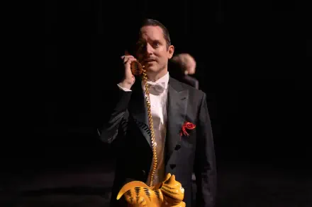 A scene from the TV show Yellowjackets, featuring Elijah Wood in a tuxedo, holding a whimsical phone. The image is a striking 4K Ultra HD wallpaper.