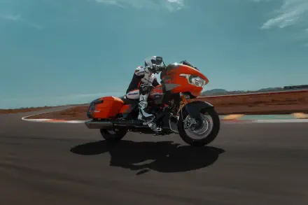 A vibrant Harley-Davidson CVO Road Glide RR motorcycle speeds around a track, showcasing its sleek design and powerful presence in stunning 4K Ultra HD.