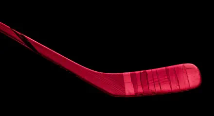 A vibrant red hockey stick isolated on a black background, captured in striking detail for a 4K Ultra HD PC desktop wallpaper.