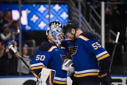 HD wallpaper featuring two NHL hockey players from the Winnipeg Jets in blue jerseys sharing a moment on the ice during a game.