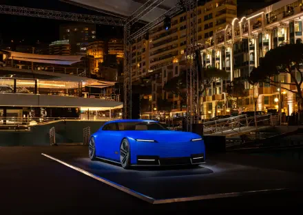 A blue Jaguar Type 00 parked at night in a brightly lit urban setting, captured in 8K Ultra HD as a PC desktop wallpaper and background.