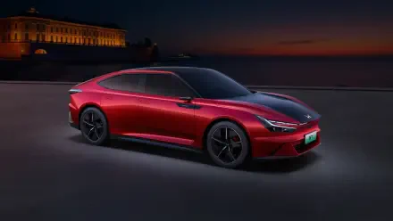 Sleek red Honda GT electric car showcased at dusk with a historic building in the background, rendered in 4K Ultra HD for a stunning desktop wallpaper.