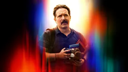 Man with a mustache holding toys and a book, backpack on, framed by vivid vertical light streaks — Superman (2025) 5K Ultra HD desktop wallpaper