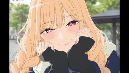 HD PC desktop wallpaper of Marin Kitagawa from My Dress-Up Darling — blushing close-up, hands framing her face, warm smile, long blonde hair, soft green outdoor background.