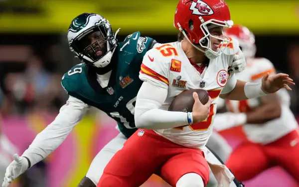 Patrick Mahomes of the Kansas City Chiefs is tackled by a Philadelphia Eagles player during an intense NFL matchup, captured in a dynamic HD desktop wallpaper.