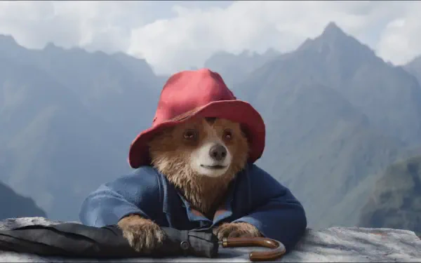 A charming HD desktop wallpaper featuring Paddington bear in Peru, set against a stunning mountainous backdrop, showcasing his adventurous spirit and beloved character.