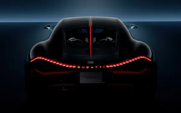 A sleek Bugatti Tourbillon captured in a striking 4K Ultra HD wallpaper, showcasing its dynamic rear design illuminated by captivating red lights against a dark background.