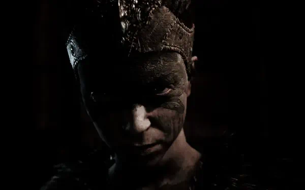A dramatic HD wallpaper featuring Senua from the video game Hellblade: Senua's Sacrifice, showcasing her fierce expression and intricate headpiece against a dark background.