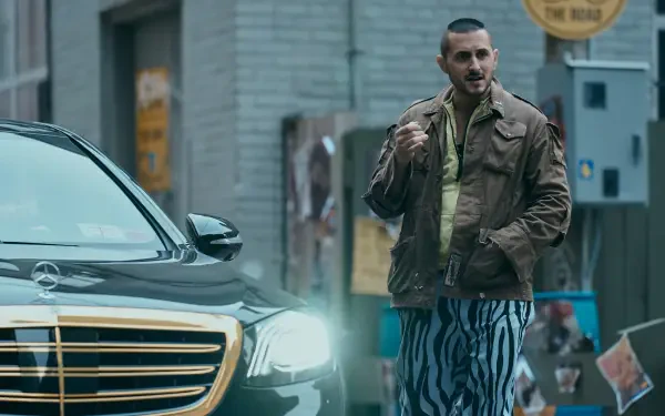A scene from The Boys (2019) featuring a character in a brown jacket and zebra-striped pants, standing next to a sleek black car in an urban setting. 4K Ultra HD quality.