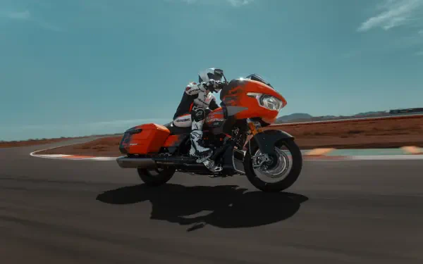 A vibrant Harley-Davidson CVO Road Glide RR motorcycle speeds around a track, showcasing its sleek design and powerful presence in stunning 4K Ultra HD.