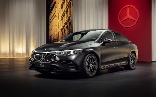 A sleek black Mercedes-Benz CLA showcased in an elegant setting, highlighting its luxury design and distinctive front grille, set against a rich backdrop.