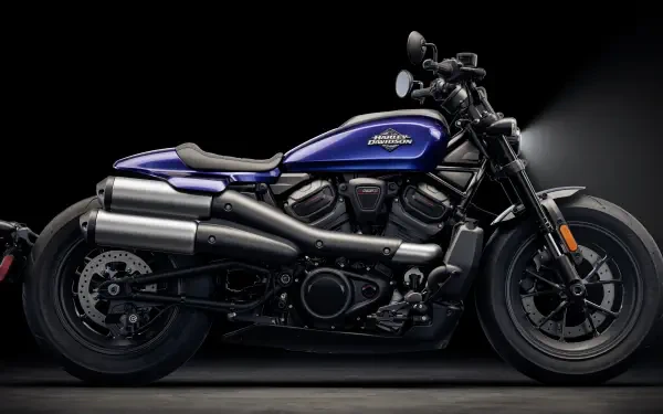 A sleek Harley-Davidson Sportster motorcycle in striking blue, set against a black background. This 4K Ultra HD image showcases the bike's powerful design and distinctive features.