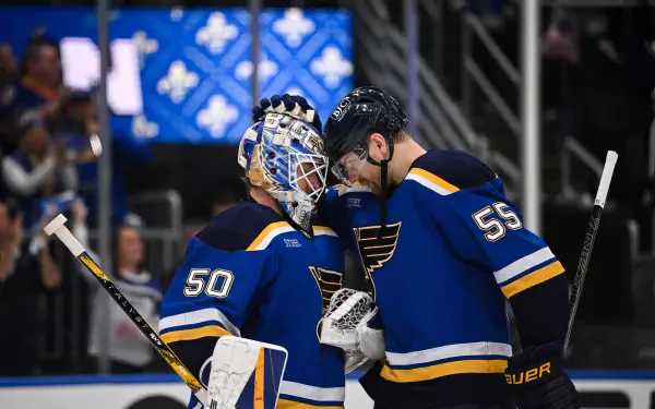 HD wallpaper featuring two NHL hockey players from the Winnipeg Jets in blue jerseys sharing a moment on the ice during a game.