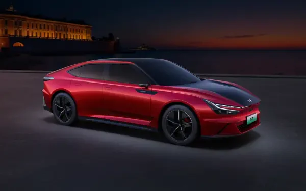 Sleek red Honda GT electric car showcased at dusk with a historic building in the background, rendered in 4K Ultra HD for a stunning desktop wallpaper.