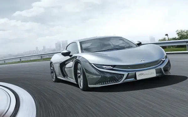 HD desktop wallpaper featuring a sleek Mullen Qiantu K50 electric car driving on a curved highway with a city skyline in the background.