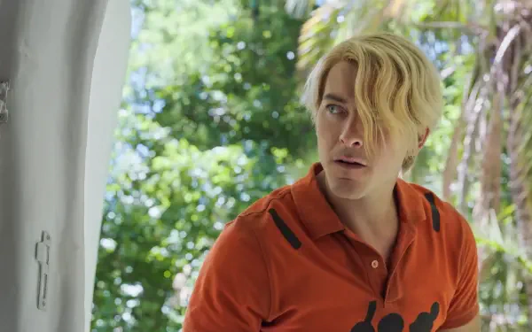 HD PC desktop wallpaper of Sanji from the One Piece live-action TV show: blond, side-swept hair and orange shirt peering from a doorway with sunlit tropical foliage.