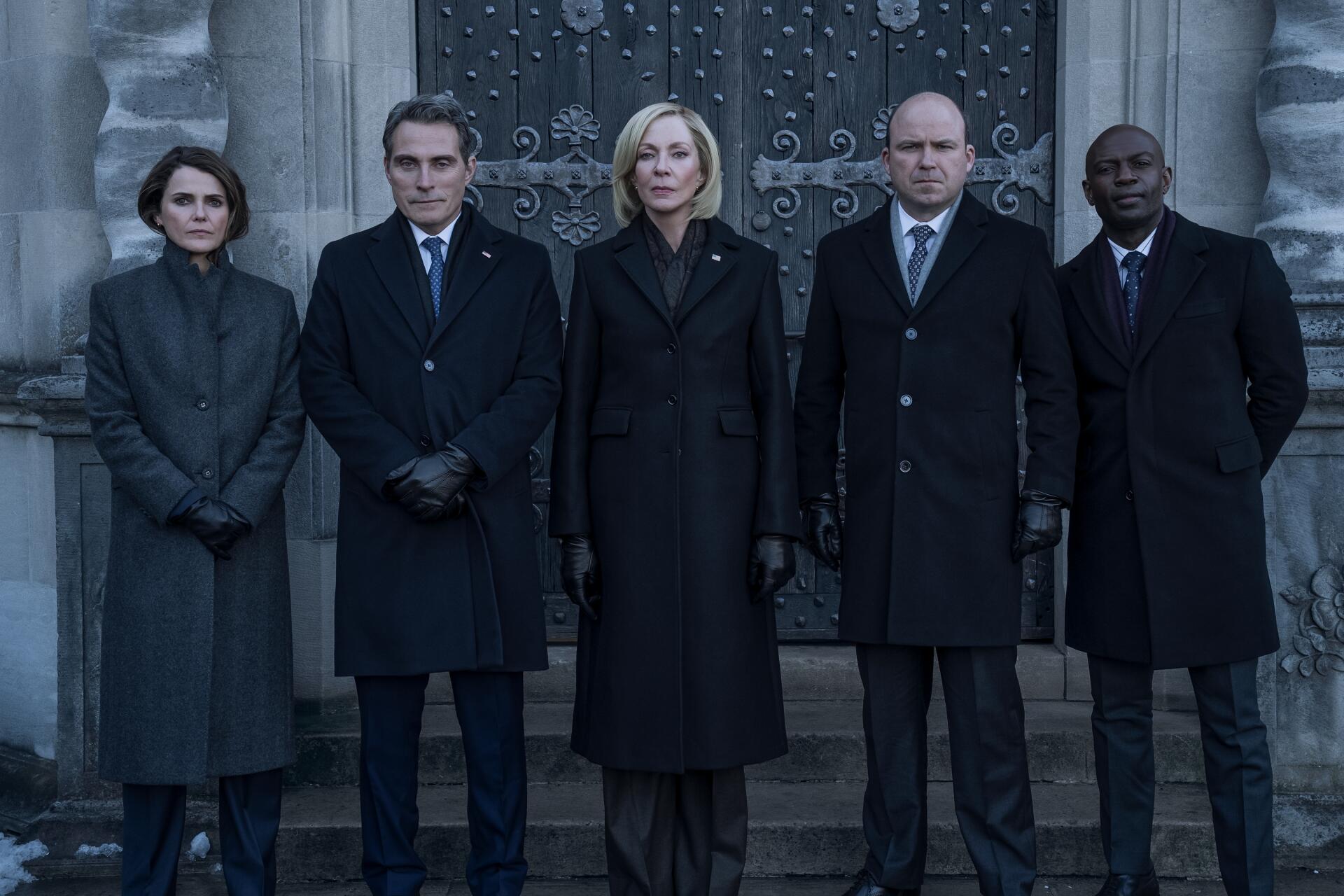 Five stern figures in dark suits and coats stand before an ornate stone doorway — promotional image from the TV show The Diplomat, 2K Quad HD PC desktop wallpaper.