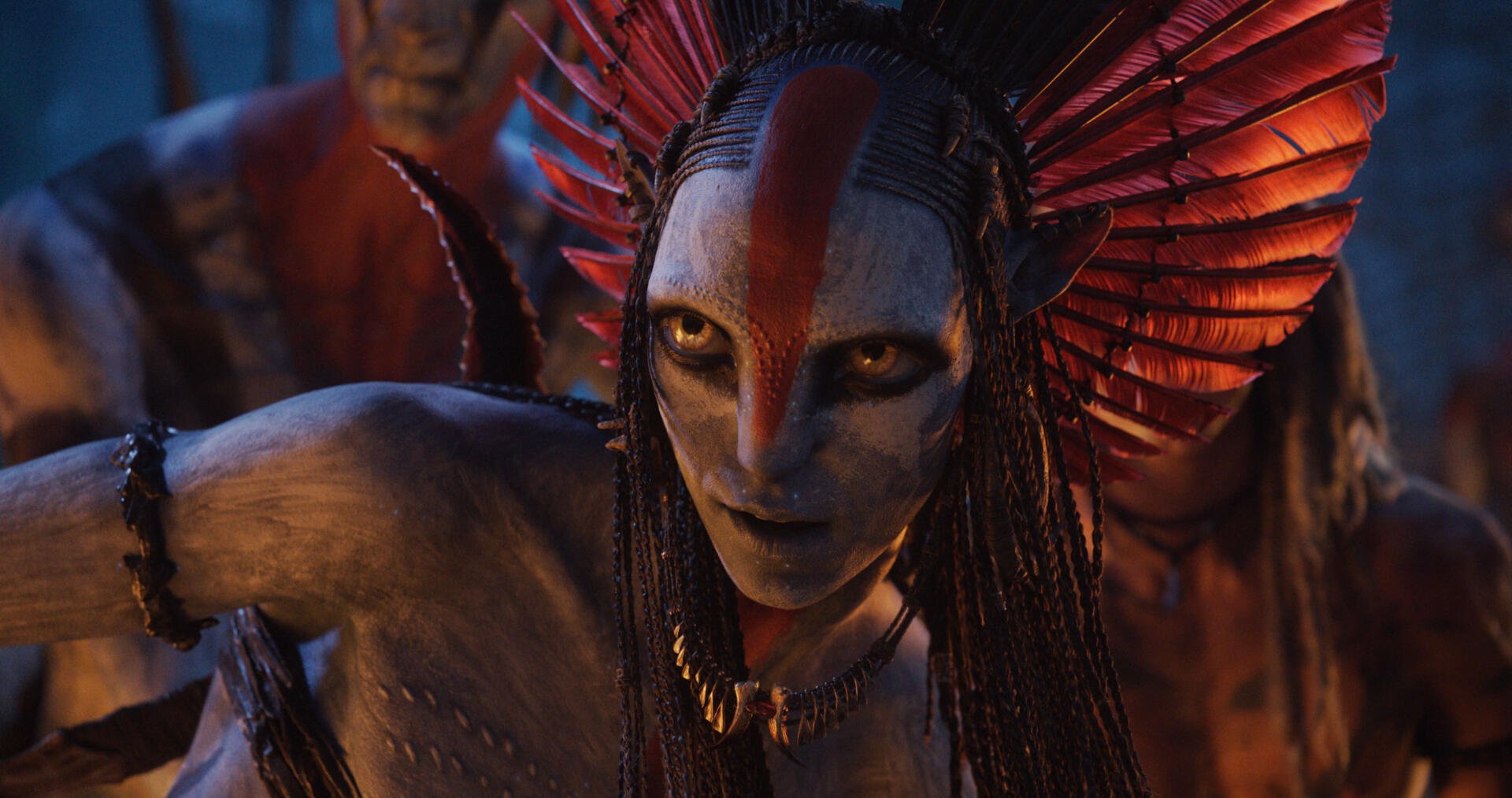 4K Ultra HD PC desktop wallpaper from the movie Avatar: Fire and Ash — close-up of a Na'vi warrior with red war paint, feathered headdress, and an intense gaze.