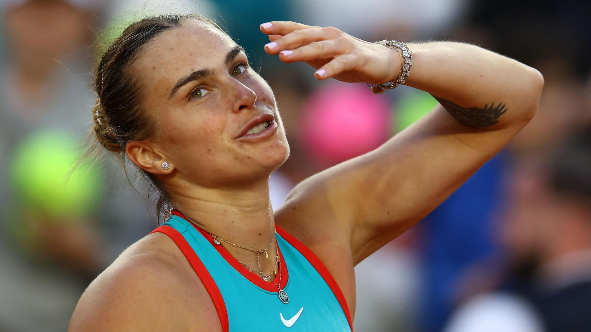 4K Ultra HD PC desktop wallpaper of a Belarusian female tennis player mid-match, wiping her brow in a turquoise top with a focused, determined expression