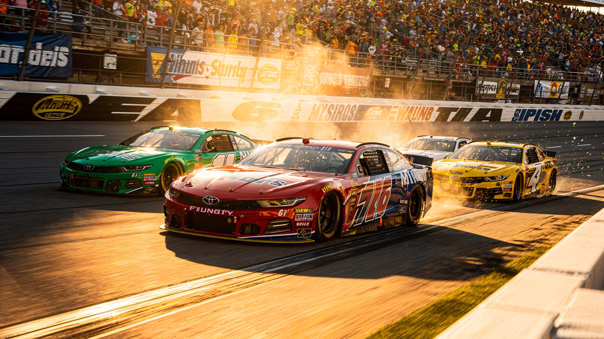 NASCAR race cars blasting past the finish line in warm sunset light, packed grandstands cheering — 4K Ultra HD PC desktop wallpaper/background.
