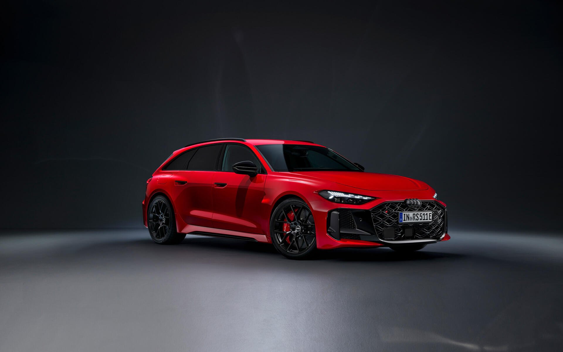 Red Audi RS5 sports car on a dark studio floor, presented as a 2K Quad HD PC desktop wallpaper/background.