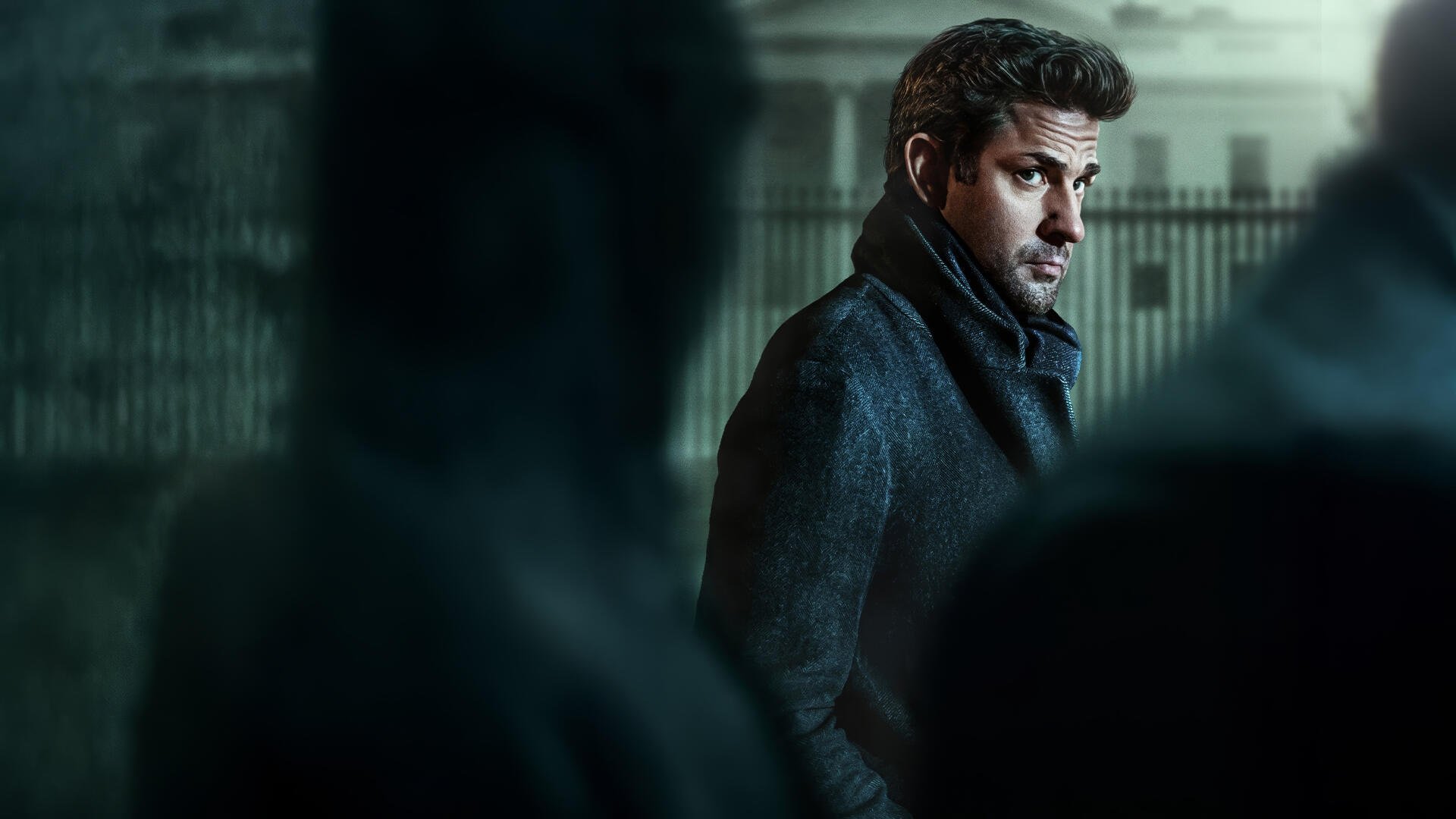 Jack Ryan in a moody, rain‑washed cityscape, glancing over his shoulder — 4K Ultra HD PC desktop wallpaper and background.