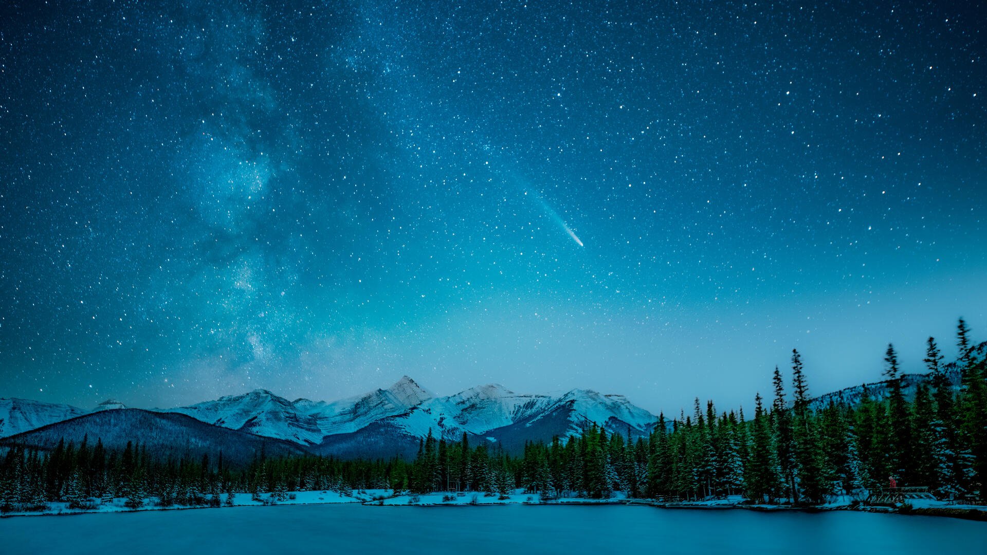 4K Ultra HD PC desktop wallpaper: a starry sky with a bright comet streaking over snow-capped mountains and a dense forest reflected in a still lake.