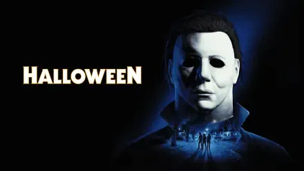 4K Ultra HD PC desktop wallpaper of Halloween videogame: a pale, expressionless killer mask looms over a moonlit suburban street with tiny figures and the bold title HALLOWEEN.