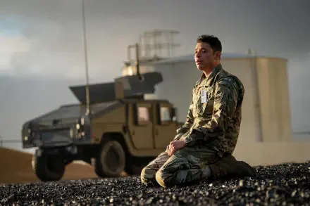 4K Ultra HD PC desktop wallpaper/background: scene from the movie A House of Dynamite — a soldier in camouflage kneels on gravel beside an armored vehicle under a hazy desert sky.